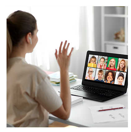 Teacher waving to K-12 students as she teaches remotely