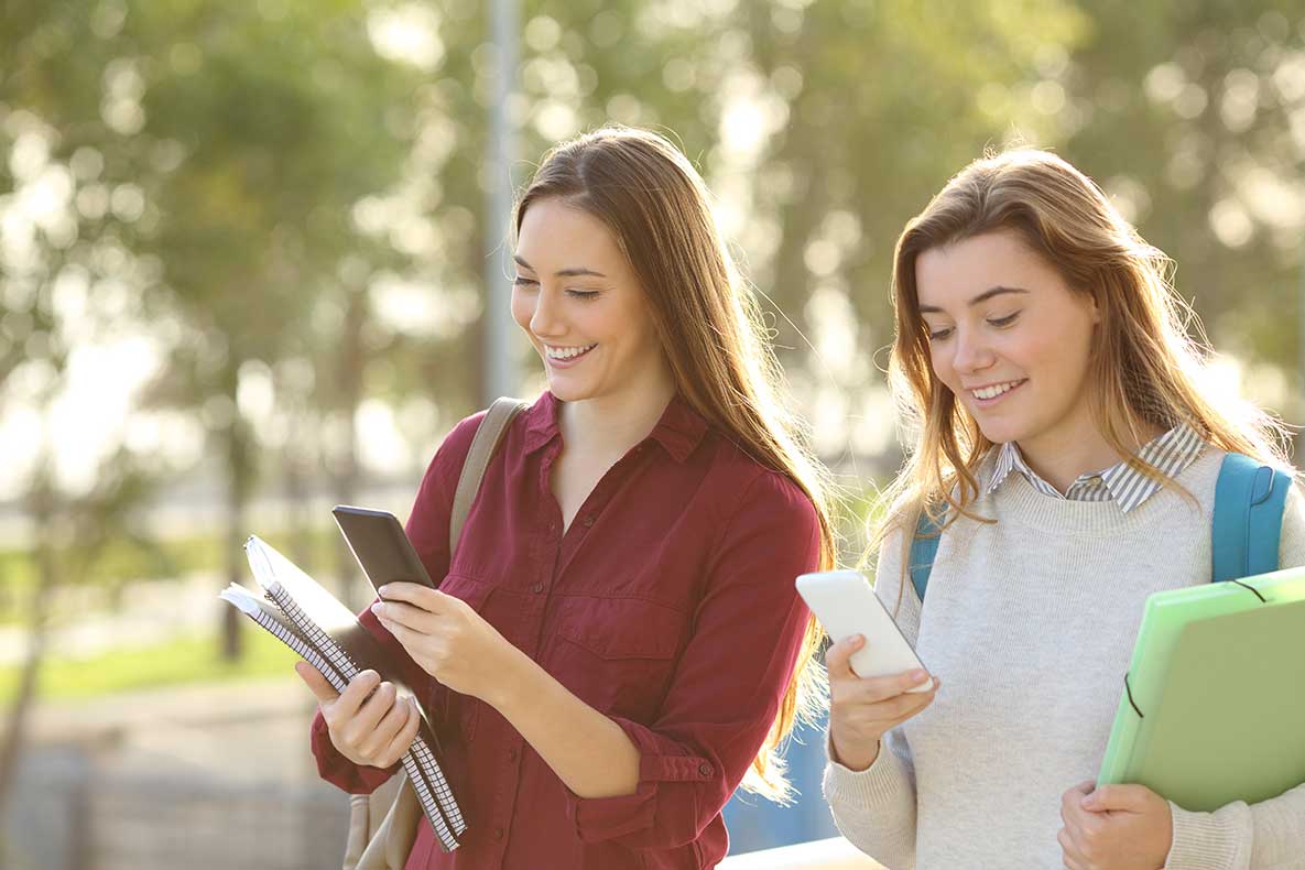 Students checking school activities using mobile phone